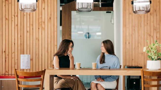 two woman having coffee together and chatting. 